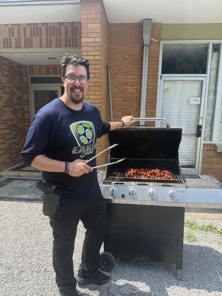 Deputy Brown is posed for a picture by the grill where he grilled up hotdogs.