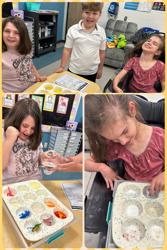 Students are seated and standing by a table where they are using muffin tins to hold paint. 
