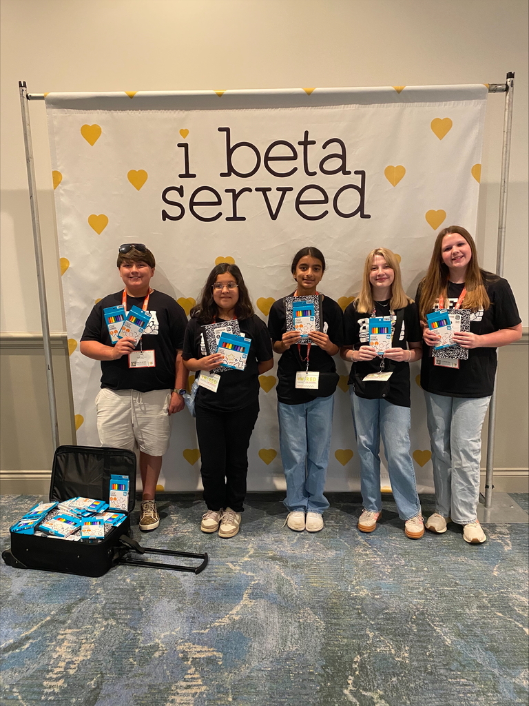 There are five students standing for a group picture with a backdrop that says, "I beta served". 