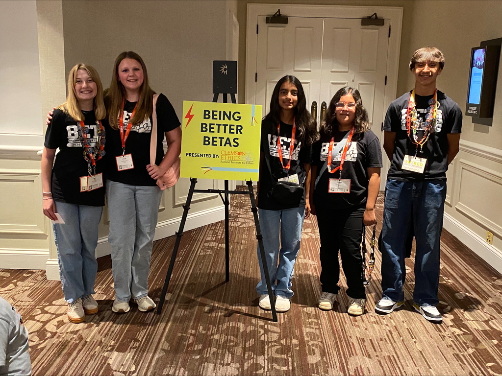 There are five students standing for a group picture with a sign that says, "Being Better Betas".