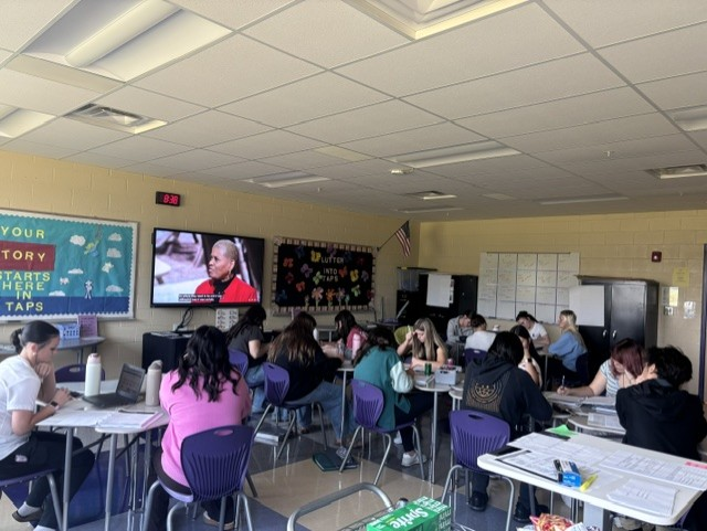 This is a picture of a classroom with several high school students all sitting at their desks.