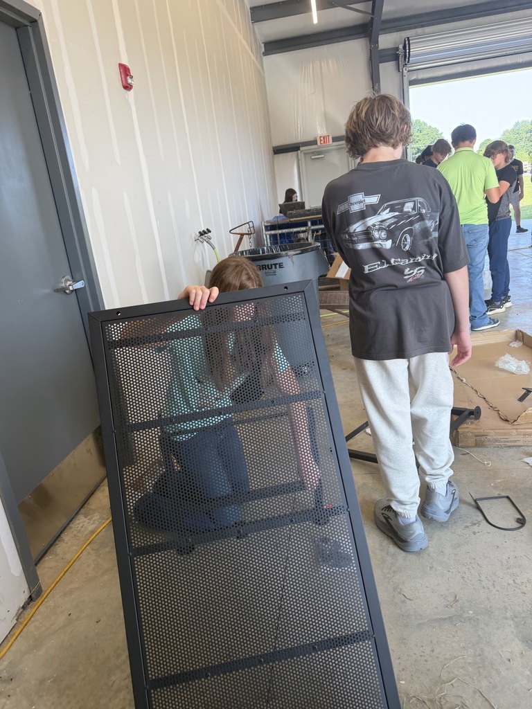 A girl is kneeling down trying to assemble a metal table