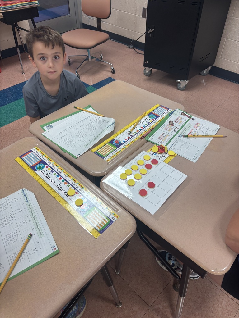 There is a student sitting at a desk while he is working on solving a math problem.