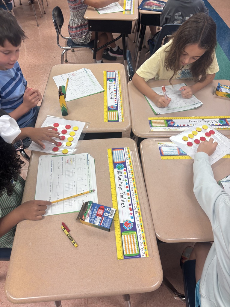 There are four students sitting at a desk while they are working on solving a math problem.