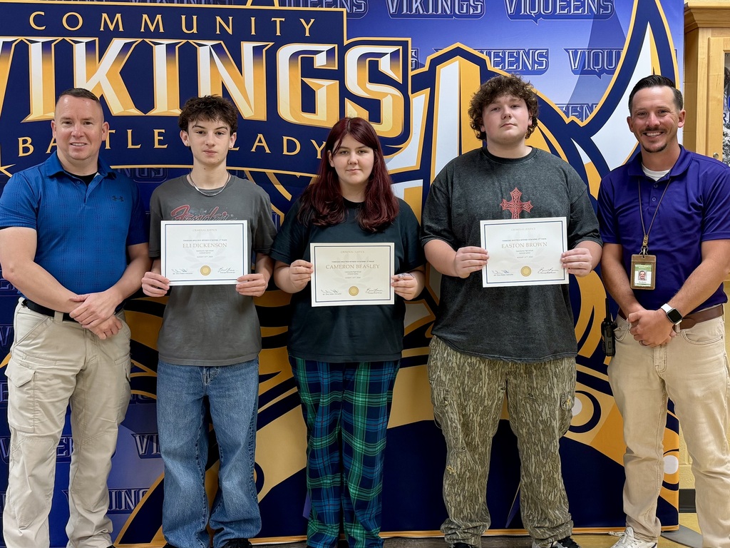 There are three students holding certificates and one adult on each side all posing for a picture in front of their school's logo. 