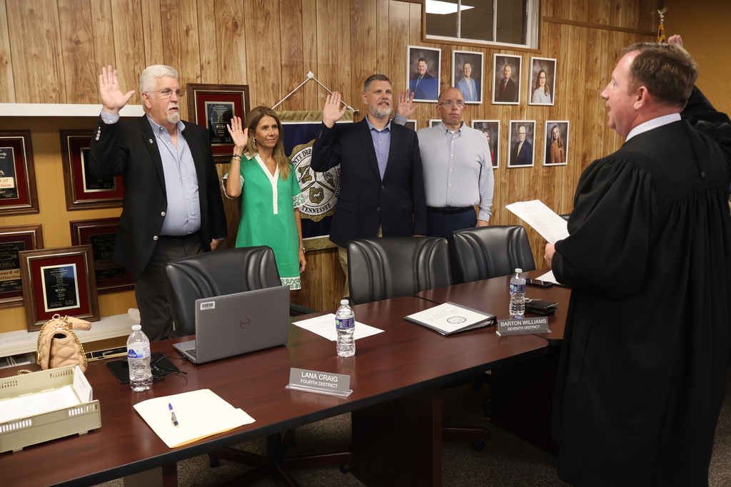 Four school board members are standing before a judge at the Central Office as they take their new Oath of Office for their new terms. 
