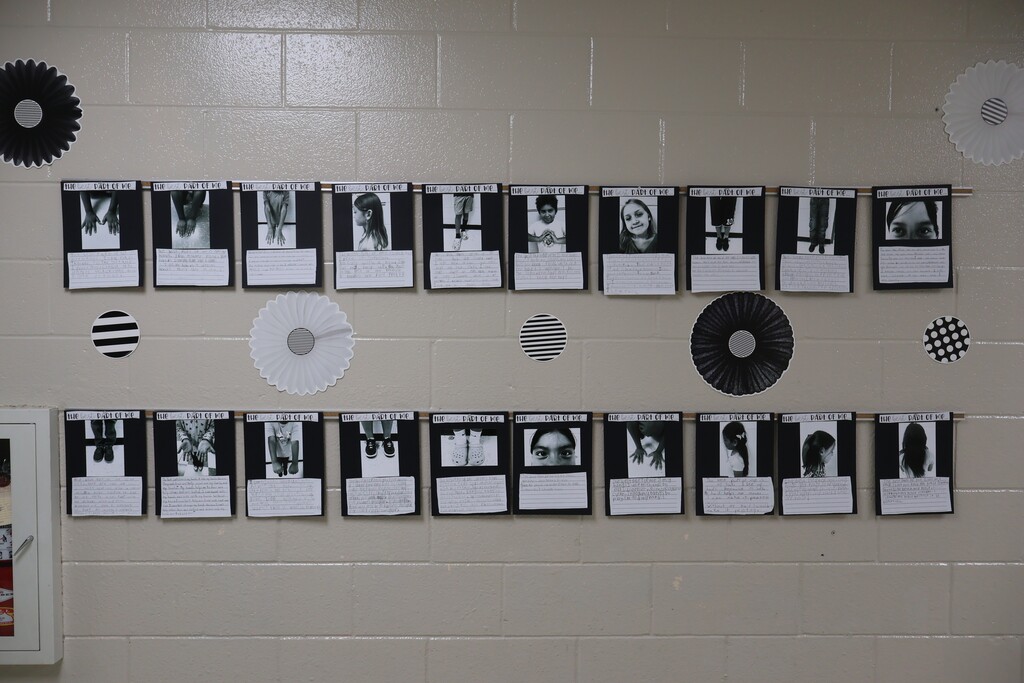 This is a picture of a wall with the black and white photos displayed on it. 