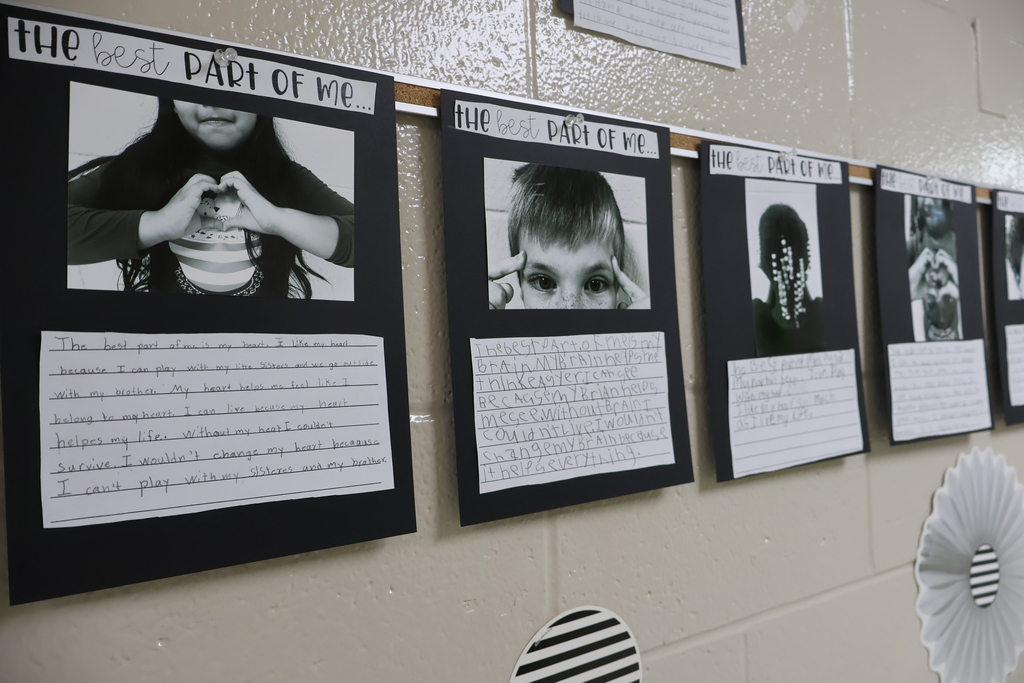 There are several black and white photos on black paper with the students write-ups underneath the photos. 