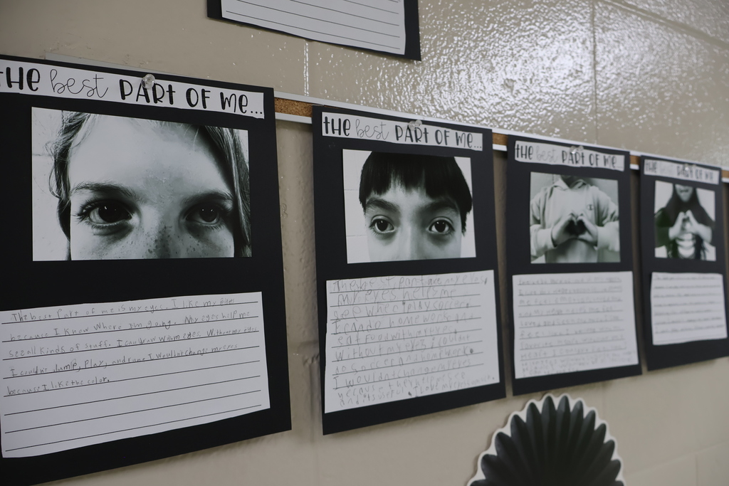 There are several black and white photos on black paper with the students write-ups underneath the photos. 
