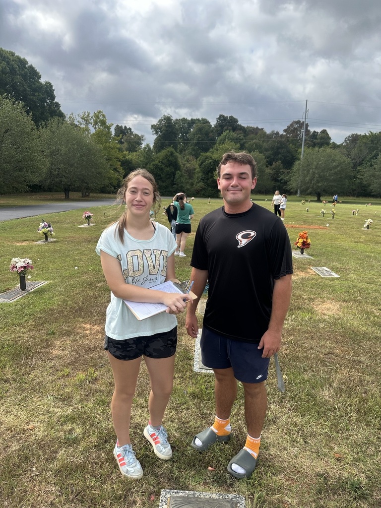 Two students are posed for a picture in the cemetery. 