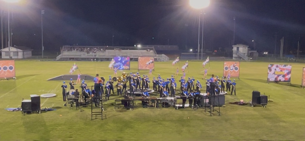 The band students are on the football field during their performance. 