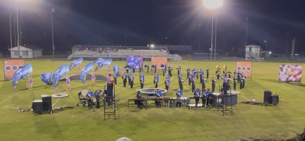 The band students are on the football field during their performance. 