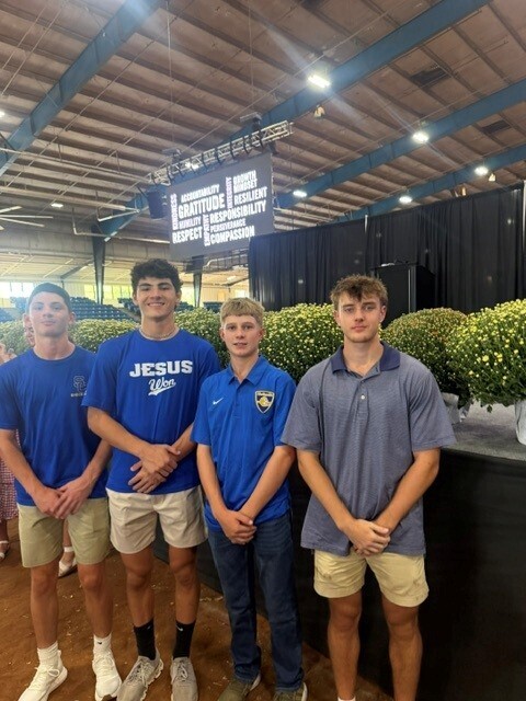 There are four students who are posing for a picture together.