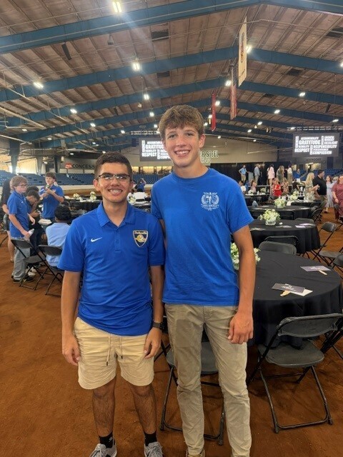 There are two students who are posing for a picture together.