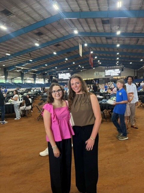 There are two students who are posing for a picture together.