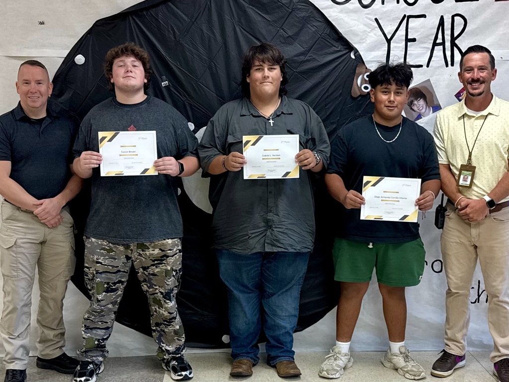 Three students are standing for a group picture with their teacher and principal while each are holding a certificate in their hands. 