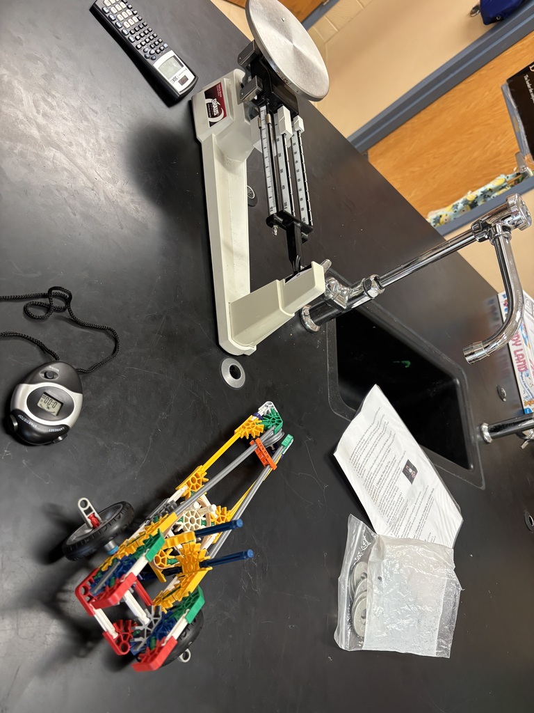 A scale and a K'nex car are on a table beside the sink. 
