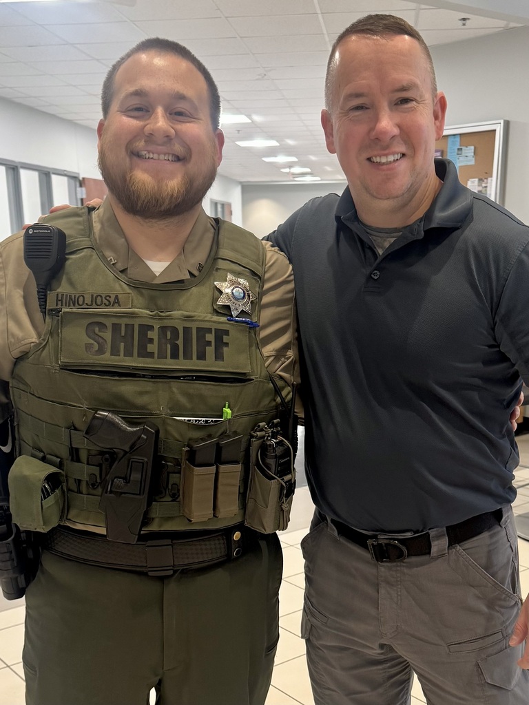 A teacher is standing with a former student who is now a deputy at the Bedford County Sheriff's Department. 