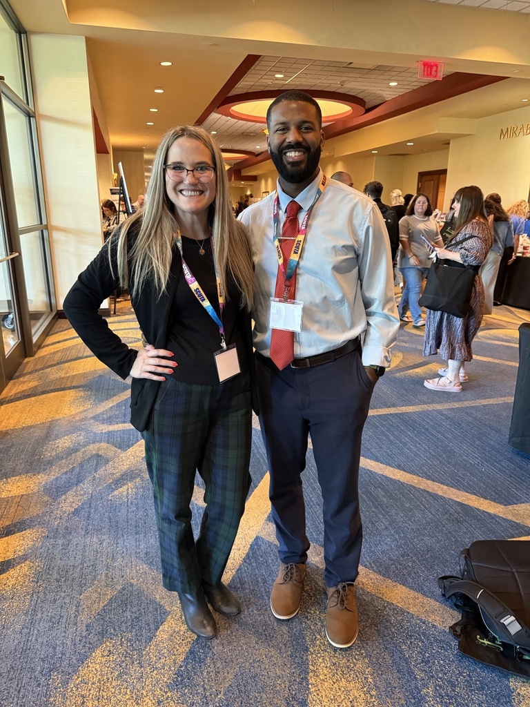 A woman and a man pose for a picture at the conference. 