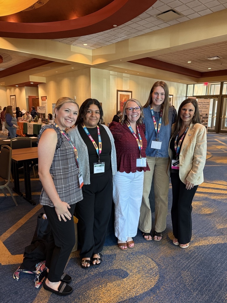 Five women pose for a group picture at the conference. 