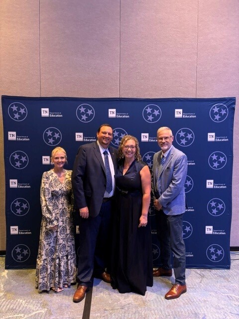 Principal Meredith Gilliland is standing beside Assistant Principal Angela Tyre, her husband and Superintendent Tim Harwell for a group picture