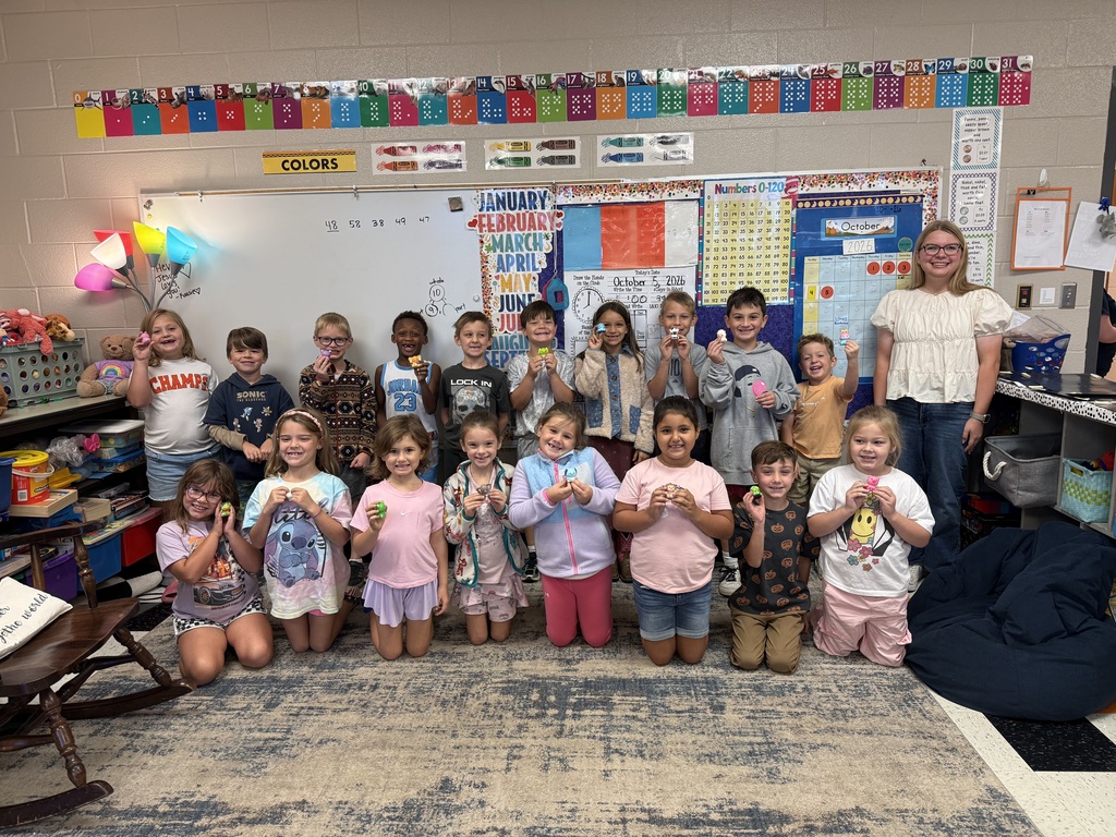 National Honor Society students from Cascade High School reading to first grade students at Cascade Elementary during Reading Buddies Day, sharing books and personal reading journeys in decorated classroom.