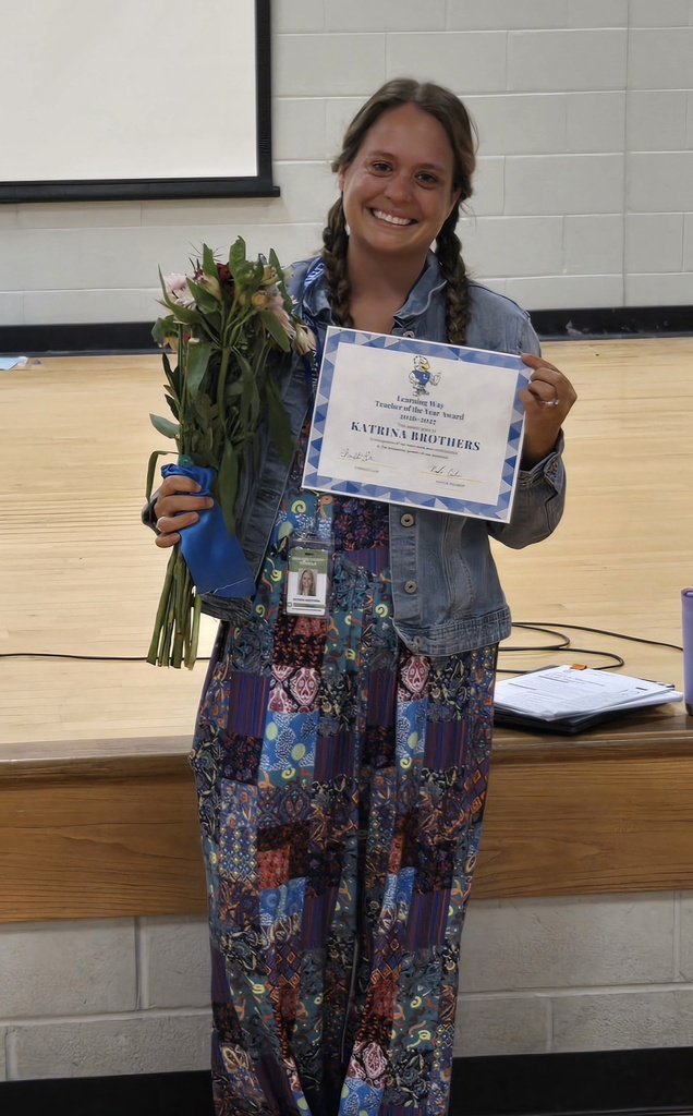 Teacher of the Year with flowers and certificate