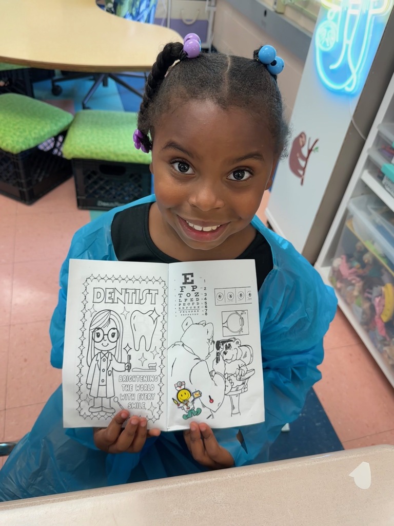 A student is holding up a coloring book she received.