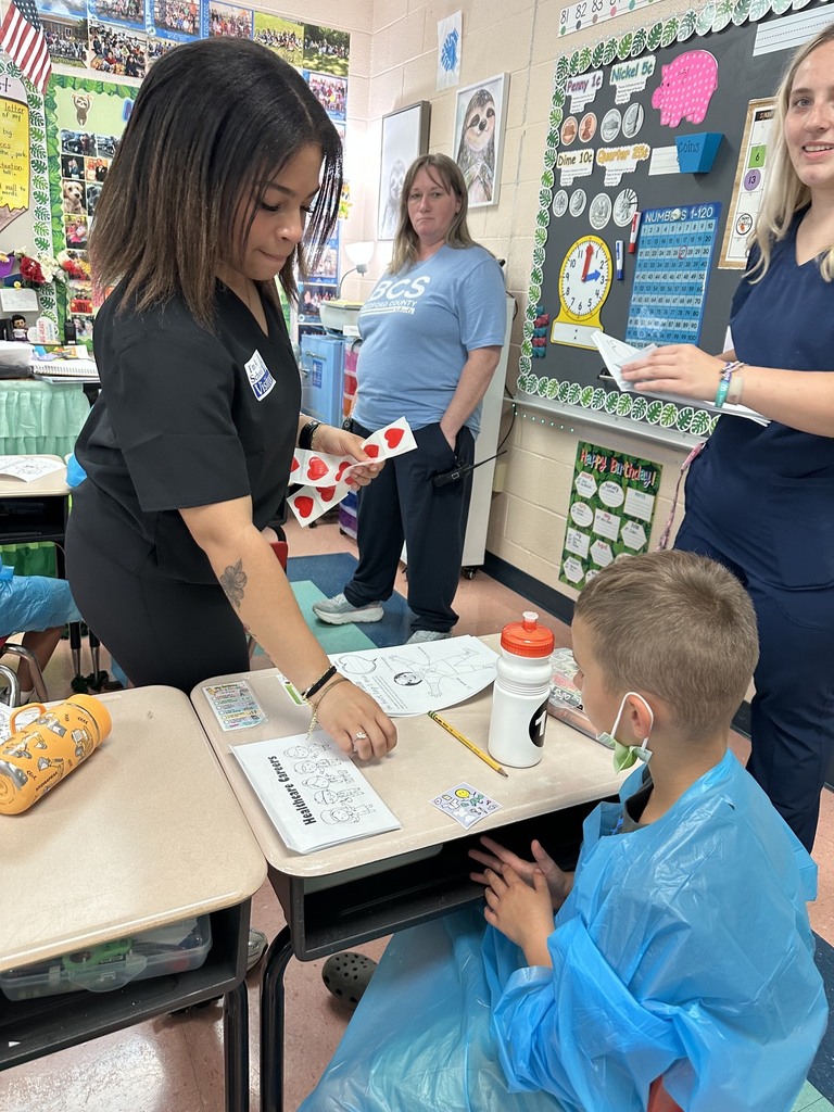 A HOSA student is sharing stickers with a younger student.