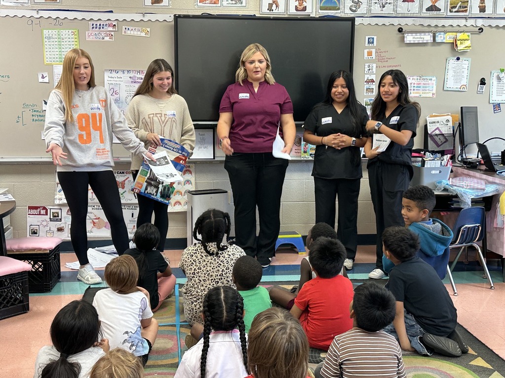 There are five HOSA students standing in front of the first graders and they are explaining more about the human body.