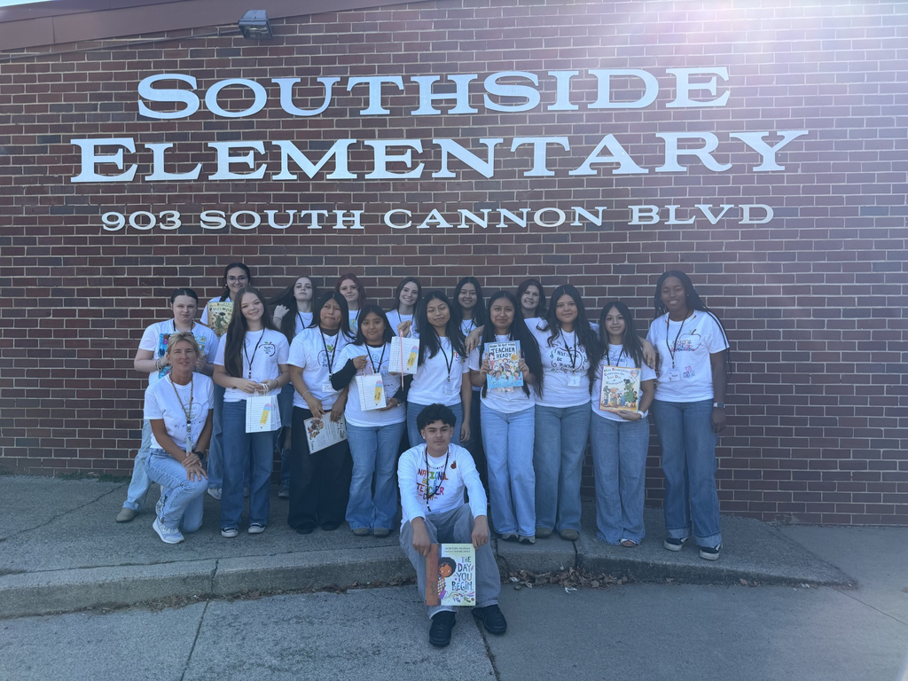 A group of high school students are posed for a picture in front of Southside Elementary School.