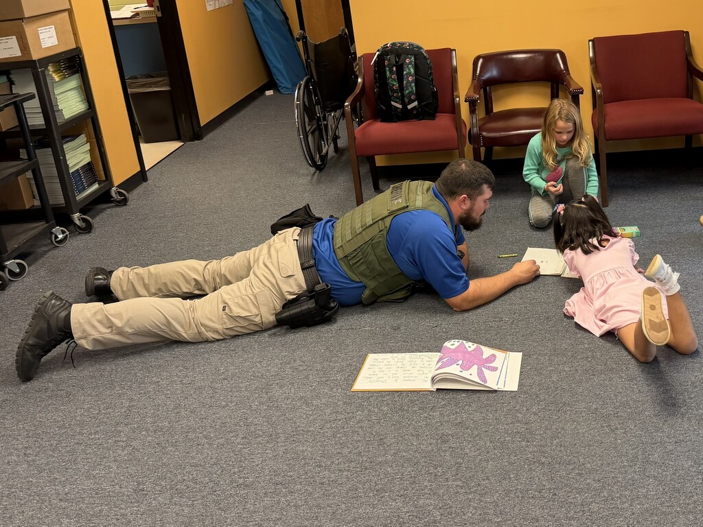Kindergarteners show Deputy Tank how to color