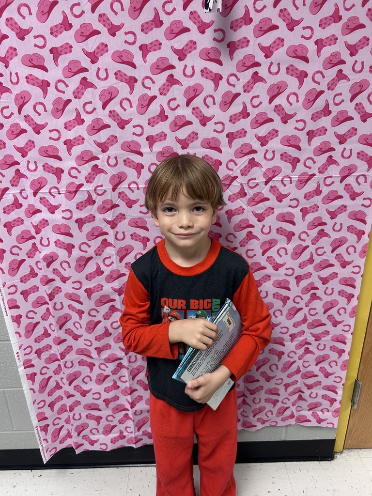 student in PJs with favorite book