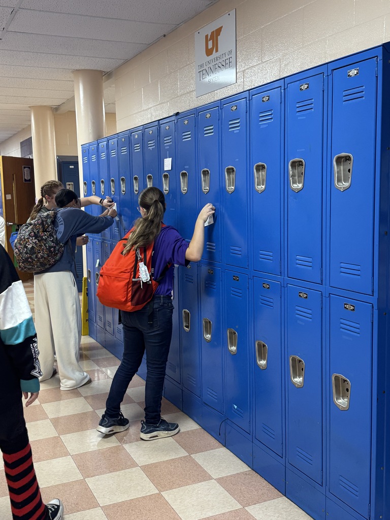 girls putting notes on lockers