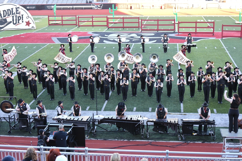 The Cascade High School marching band is on the football field during their performance. 