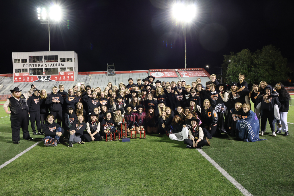 The Cascade High School marching band is on the football field during their performance.