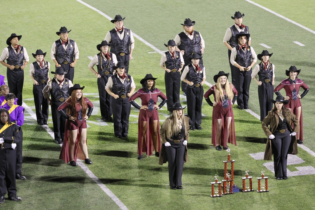 The Cascade High School marching band is on the football field during their performance.