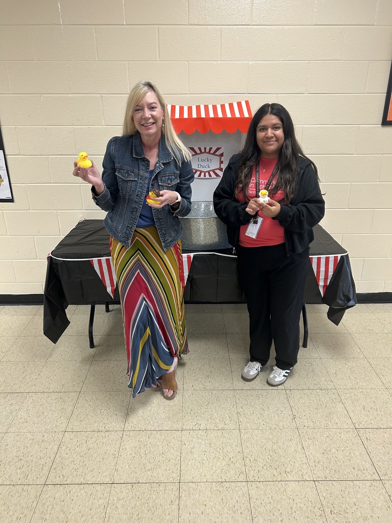 Two women are playing a circus themed game in the cafeteria.