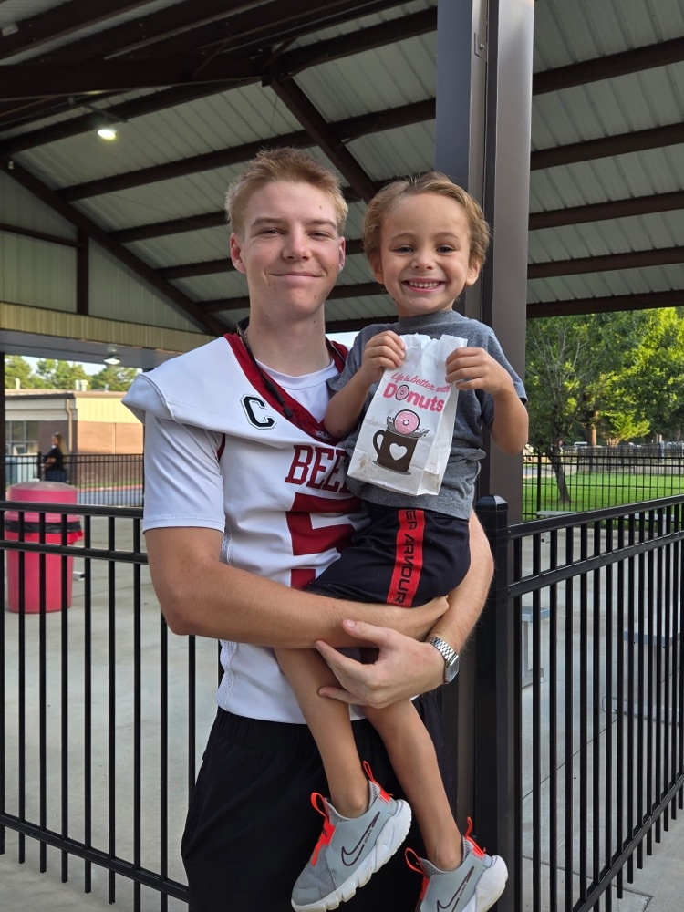 football and cheerleaders with pre-K student