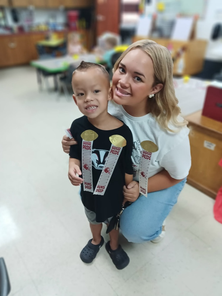 football and cheerleaders with pre-K student