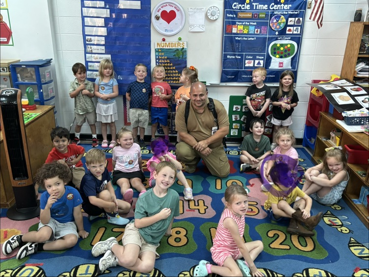 Officer Nappy reading a book to pre-K students.