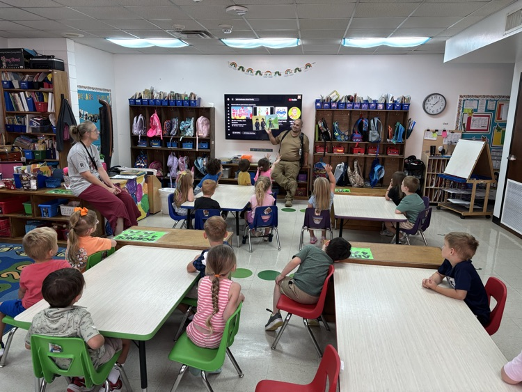 Officer Nappy reading a book to pre-K students.