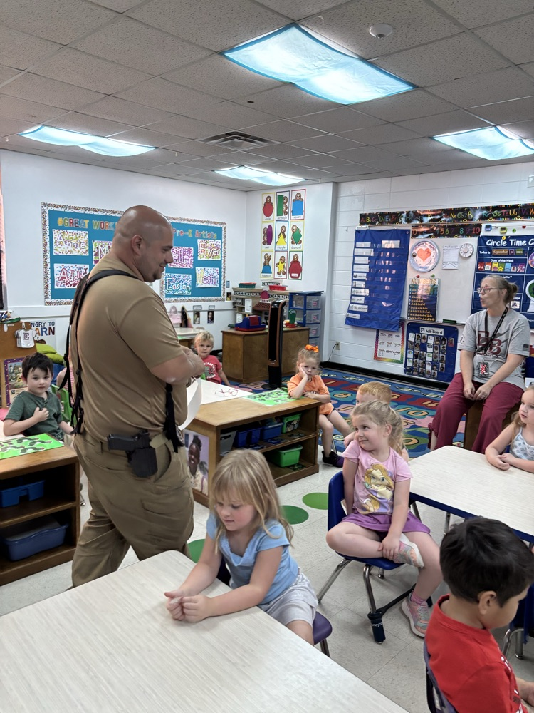 Officer Nappy reading a book to pre-K students.