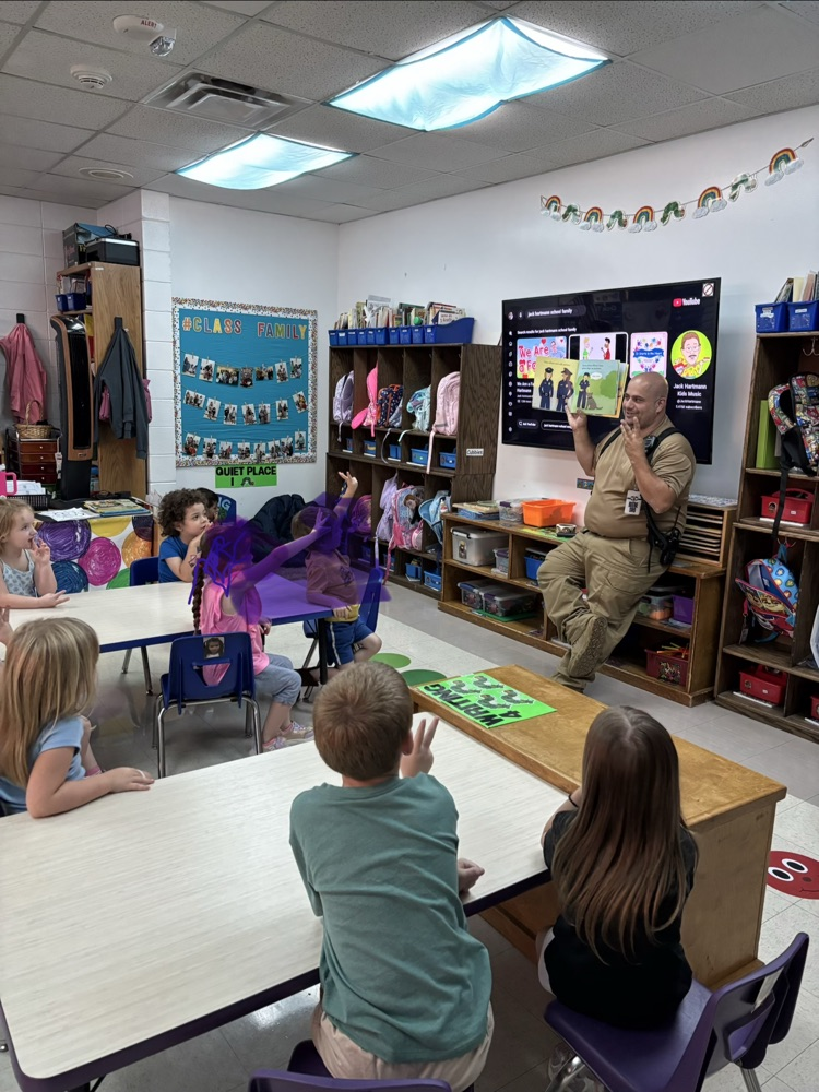 Officer Nappy reading a book to pre-K students.