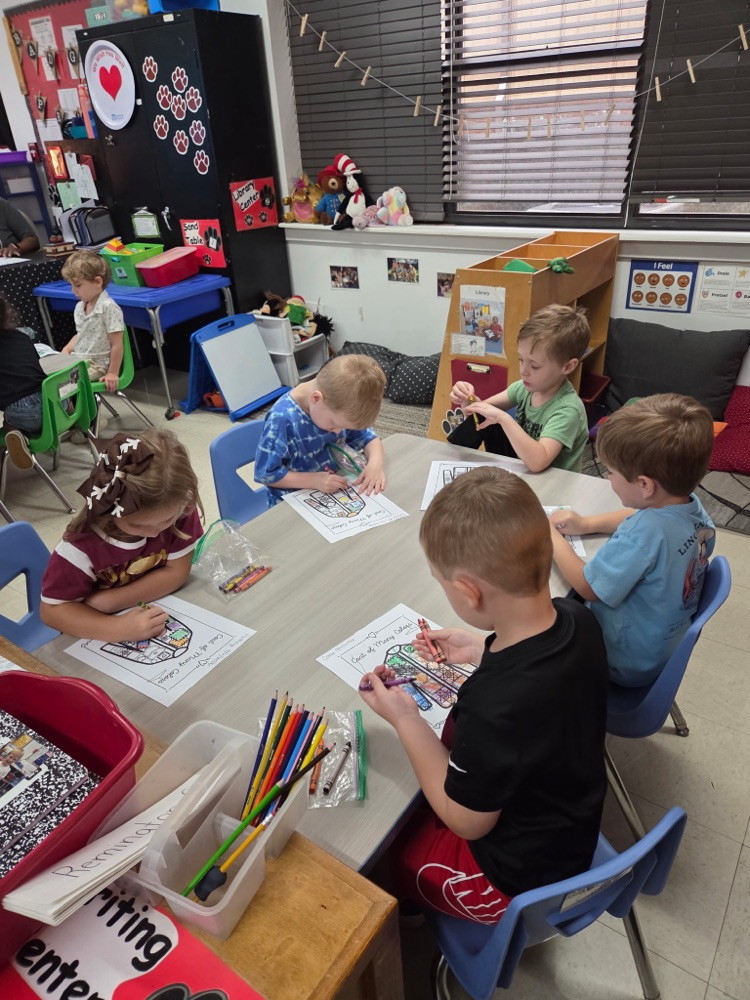 Pre-K students coloring coat of many colors