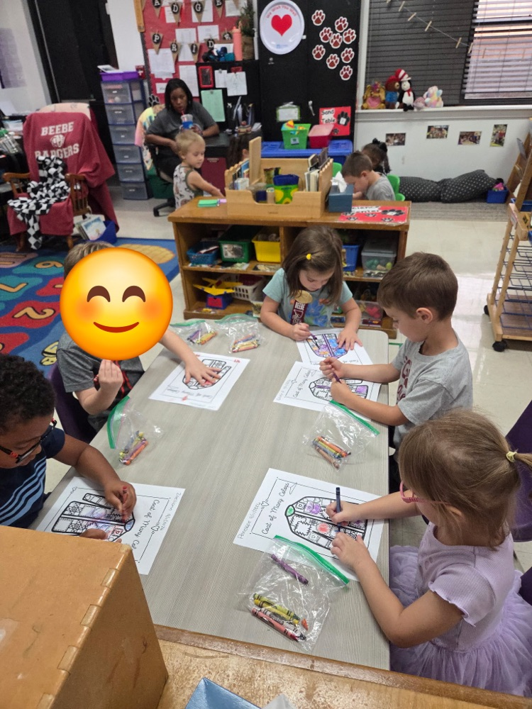 Pre-K students coloring coat of many colors