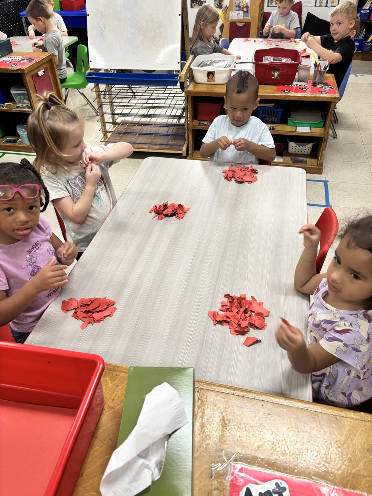 Students tearing paper to make an apple craft  