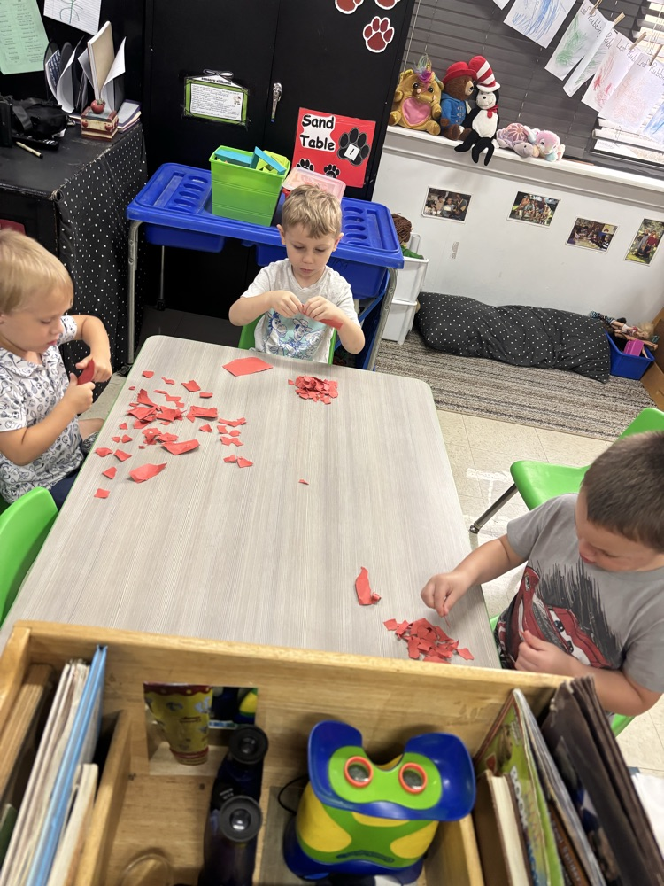 students tearing paper to make apple craft 