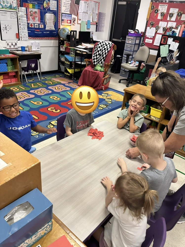 students tearing paper to make an apple craft 