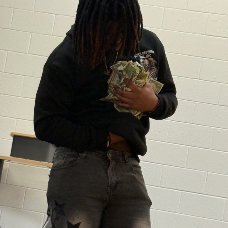 Student hold money won from the Golden Ticket Assembly 